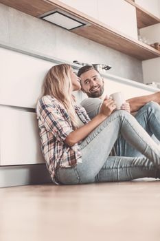 close up. young couple drinking coffee sitting on the kitchen floor