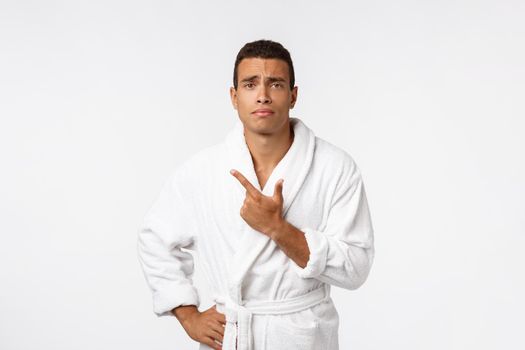 African American guy wearing a bathrobe pointing finger with surprise and happy emotion. Isolated over whtie background.