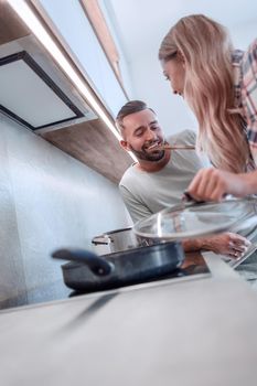 close up. young husband and wife cook dinner together