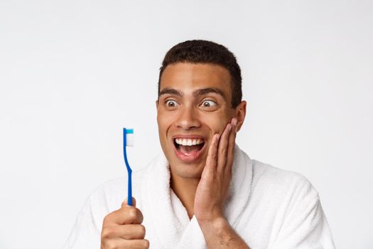 Man with tooth brush. African man holding a toothbrush with tooth brush and smiling while standing over white background