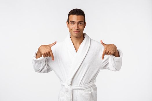 African american guy wearing a bathrobe pointing finger with surprise and happy emotion. Isolated over whtie background