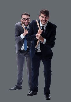 full length . two businessmen pulling a long rope. isolated on white background.