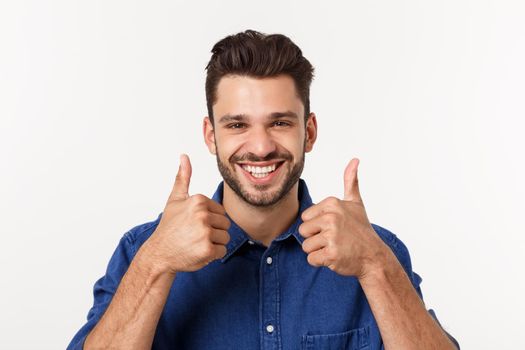 Happy casual young man showing thumb up and smiling isolated on white background