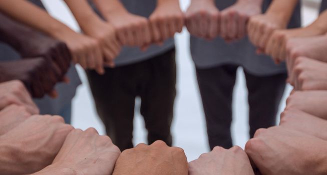 close up. a group of young people making a circle out of their hands