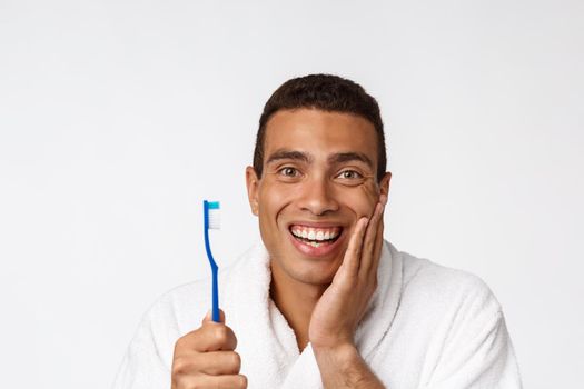 Man with tooth brush. African man holding a toothbrush with tooth brush and smiling while standing over white background