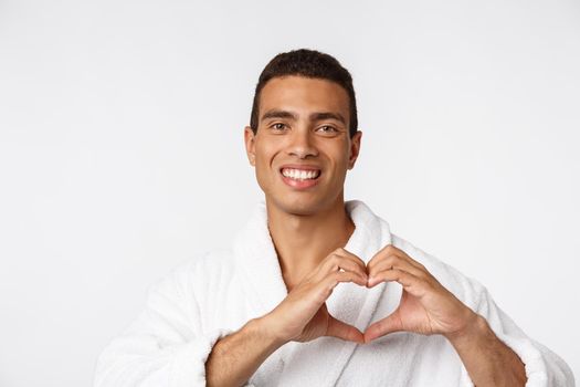 African American guy wearing a bathrobe with happy emotion. Isolated over whtie background