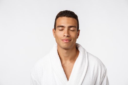 African American guy wearing a bathrobe with happy emotion. Isolated over whtie background