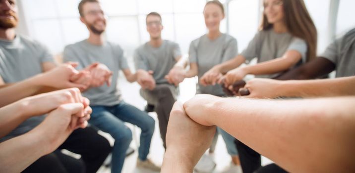 close up. a group of diverse young people holding hands