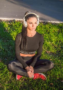Fit girl listening to music./Fitness woman outdoors with headphones.