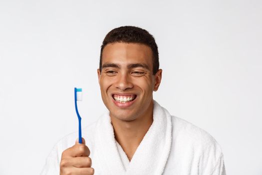 Man with tooth brush. African man holding a toothbrush with tooth brush and smiling while standing over white background