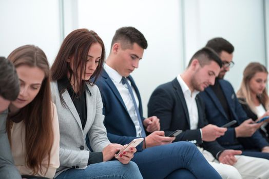 close up. a group of young people waiting, sitting in the queue