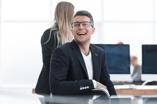 close up. smiling business man sitting at an office Desk.