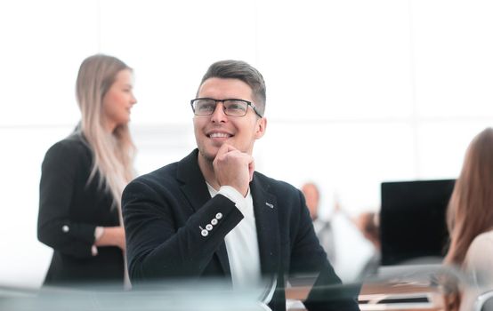 close up. smiling business man sitting at an office Desk.