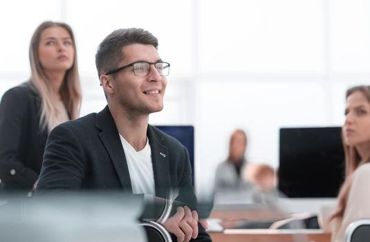 close up. smiling business man sitting at an office Desk.