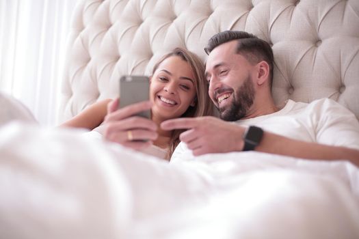 close up. smiling young couple reading e-mails on their smartphone