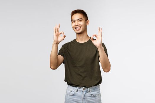 Excellent work done. Portrait of satisfied asian man showing okay gesture and smiling pleased, give approval, permition, praise friend gor nice job, recommend awesome product or movie.