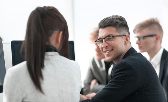 young businessman sitting among his colleagues at a meeting. the concept of teamwork