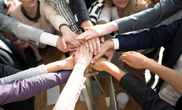 close up. group of young business people putting their palms together. concept of team building