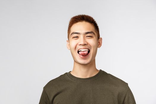 People, different expressions and lifestyle concept. Close-up portrait of upbeat, rejoicing asian man saying yes, show thumb-up in approval, praise nice job, recommend best quality, great deal.