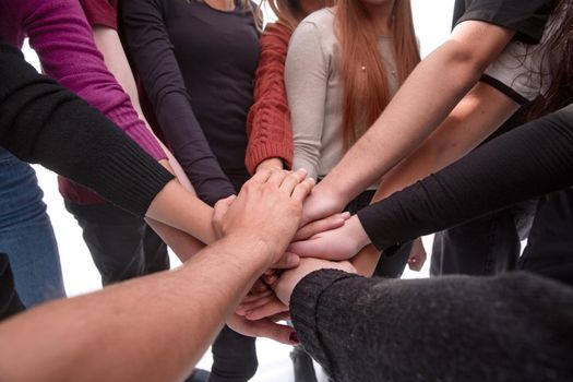 group of diverse young people making a tower out of their hands. the concept of unity