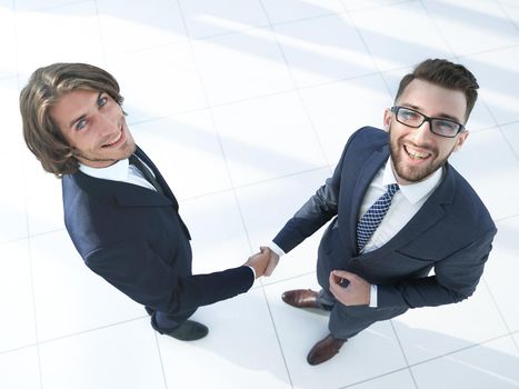 Image of a firm handshake between two colleagues in the office..