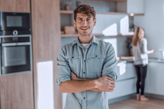 handsome young man standing in his kitchen. photo with copy space