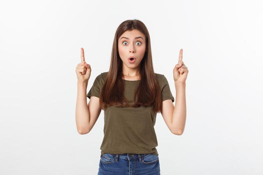 Portrait happy and surprised young lady standing isolated over grey background. Looking camera pointing