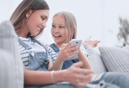 close up.happy mom and her daughter are watching videos on smartphone.photo with copy space