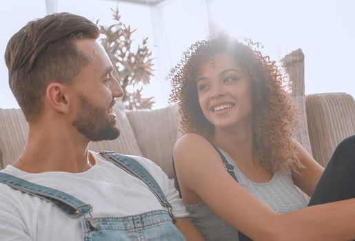 Newlyweds sitting on the couch in a new apartment. Housewarming.