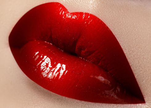 Close-up of female lips with bright makeup. Macro of woman's face. Fashion lip make-up with red gloss.Red lipgloss makeup on full female lips