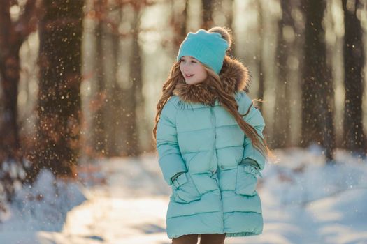 happy girl in turquoise jacket and hat