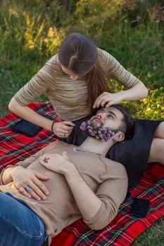 woman with a man in whose beard flowers in nature