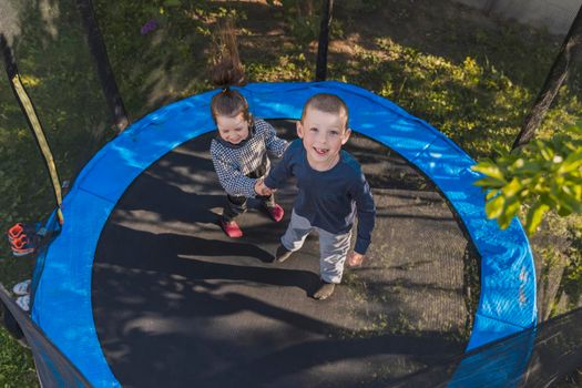 children jumping on a trampoline top view