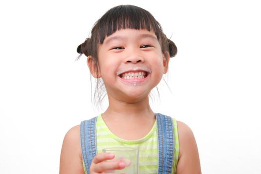 Portrait of a cute Asian little girl holding a glass of milk isolated on white background. Small girl at home with smiling face, feeling happy enjoying drinking milk and looking at camera.