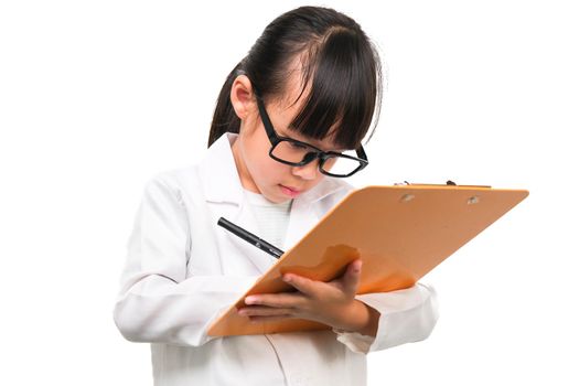 Portrait of a little scientist holding a pen writing on a clipboard on a white background. A little girl role playing in a doctor or science costume.