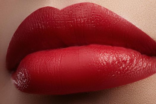 Close-up of female lips with bright makeup. Macro of woman's face. Fashion lip make-up with red gloss.Red lipgloss makeup on full female lips