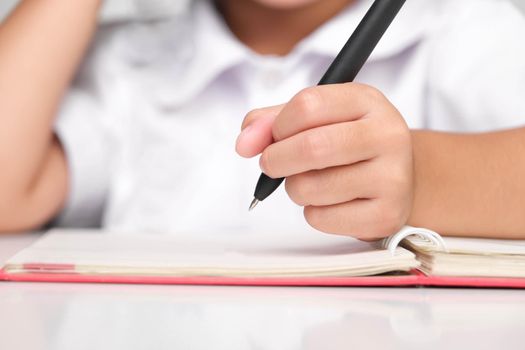 Small businesswoman taking notes while working in the office, close up. Children and business concepts