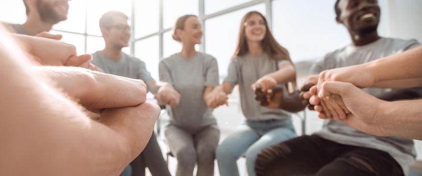 close up. United team of young people sitting in a circle. the concept of unity