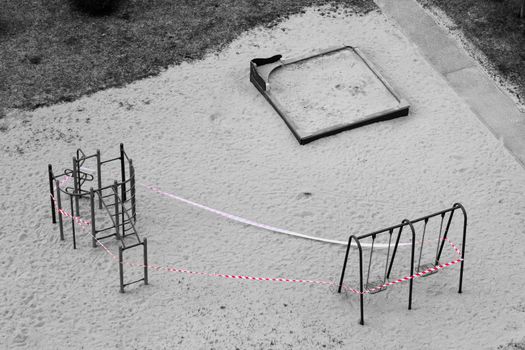 Playground equipment is closed due to Covid-19. Top view of Uninhabited place during a pandemic. Red stop ribbon on teeter. Stay at home