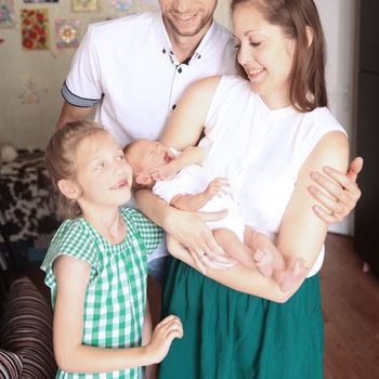 dad,daughter and mom with a newborn baby in the room for children