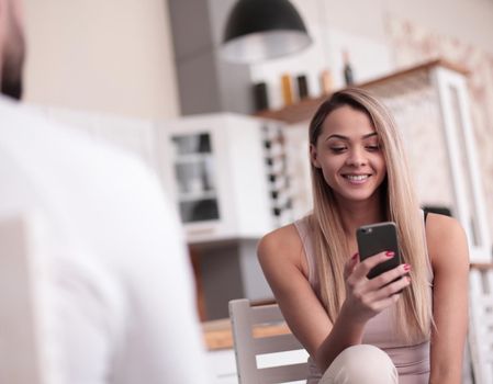 close up. smiling young woman looking at the correspondence on her smartphone