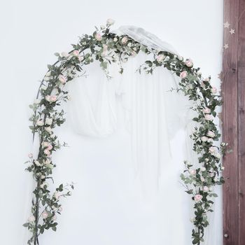 Arch for the wedding ceremony, decorated with cloth and flowers.