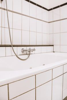 White and black tiled bathroom with white bath