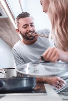 close up. young husband and wife cook dinner together