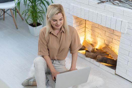 Woman in a cozy interior using a laptop. Women's hobby, searching for references and materials, learning.