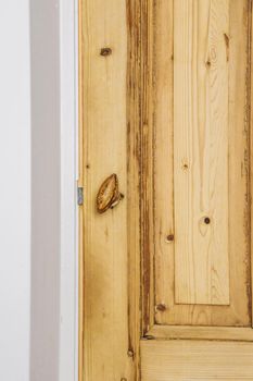 A wooden entrance door with a simple opener