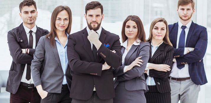 close-knit business team standing next to each other and arms crossed in front of him in the lobby of the office