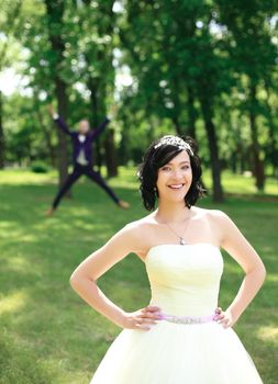 in the foreground a happy bride standing in a Park on a summer day