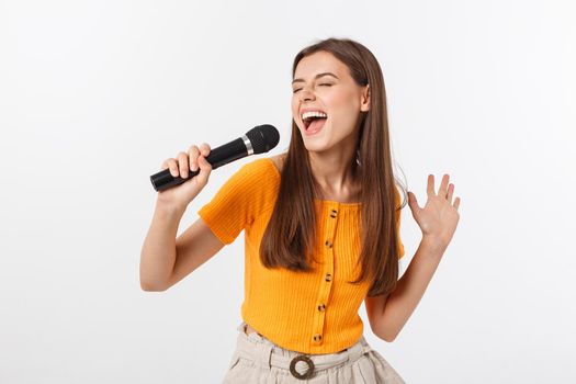 Young pretty woman happy and motivated, singing a song with a microphone, presenting an event or having a party, enjoy the moment.