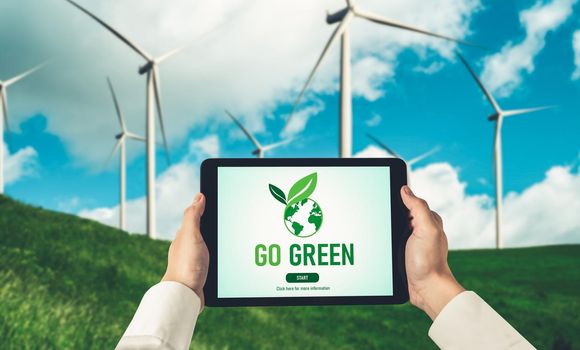 Green business transformation for environment saving and ESG business concept. Businessman using tablet to set corporate goal toward environmental friendly management and alternative clean energy use.